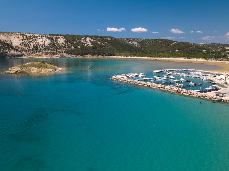 Die Bucht von Rajska Plaza, mit klarem Wasser vor hügeliger Küstenlandschaft