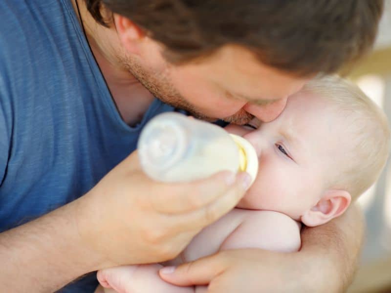 Vater füttert Baby mit Flasche