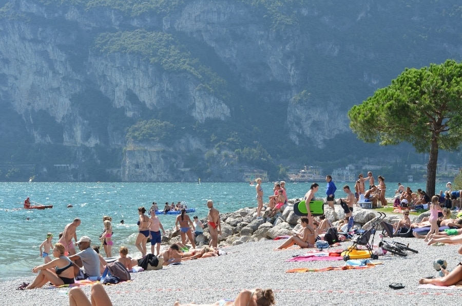 Ein Strand mit Urlaubern vor einem atemberaubenden Bergpergpanorama