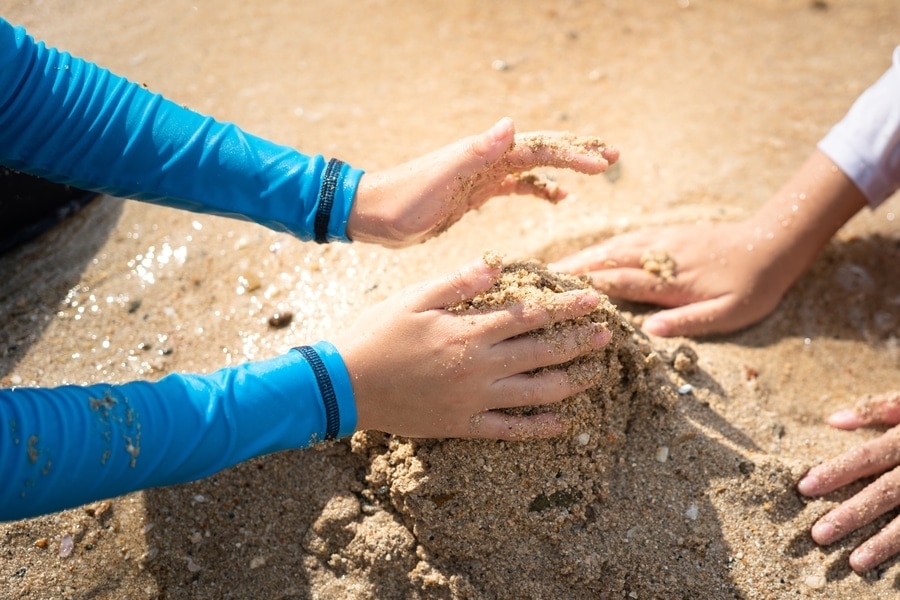 Kinder bauen eine Sandburg.