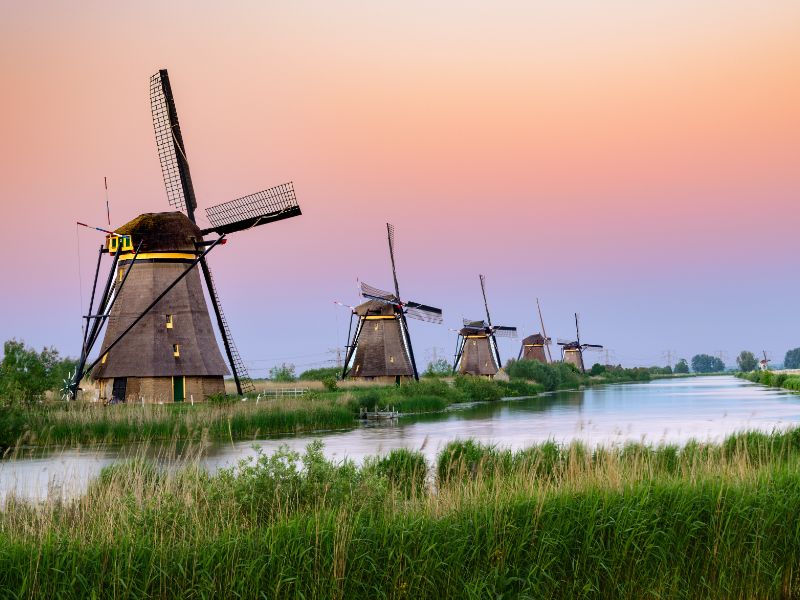 Fünf Windmühlen am Wasser in Kinderdijk in Südholland beim Sonnenuntergang