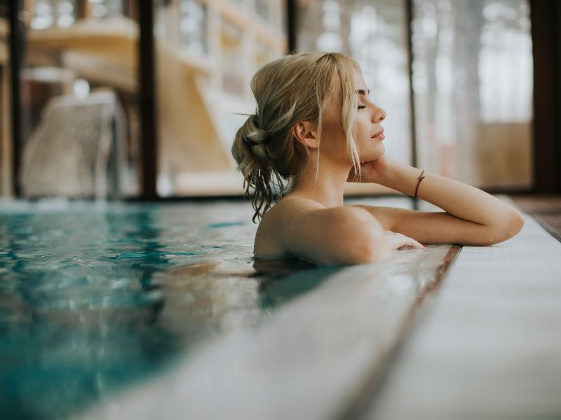 Frau im Schwimmbad, die die Ruhe im Schwimmbecken genießt