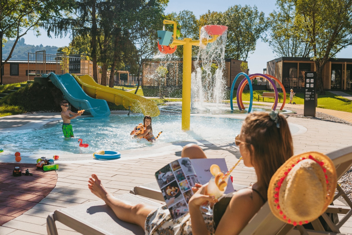 Camp Vita Glamping Village Terme Tuhelj – Tuheljske Toplice, Kroatien Frau entspannt mit einer Zeitschrift vor dem (Kinder)pool