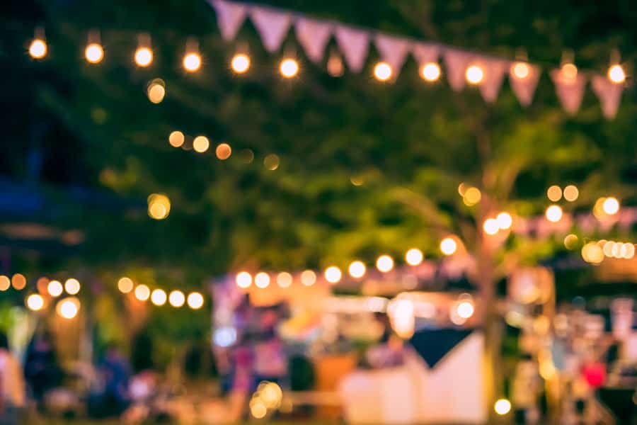 verschwommenes Foto von Lichtern und Marktständen am Abend