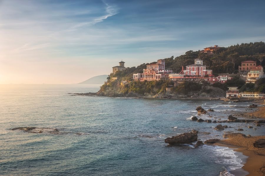 Strand mit Felsen und rauen Hügeln mit Gebäuden, Meerblick