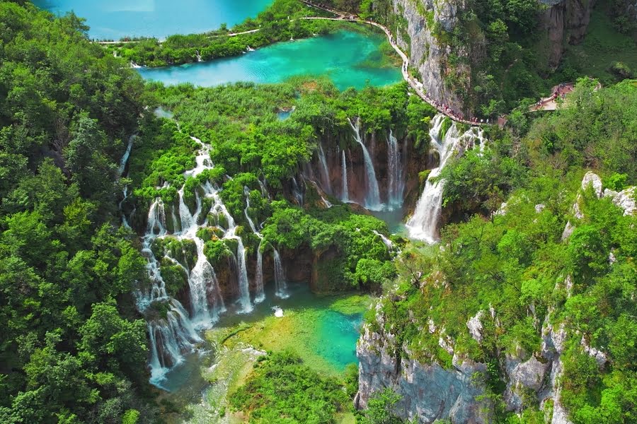 Luftaufnahme eines grünen Parks mit mehreren Wasserfällen und Wanderwegen